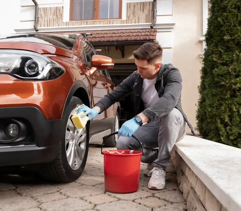 Lavage auto à domicile Fresney-le-Puceux : professionnel intervenant sur un véhicule